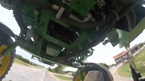 Biker Rides Underneath Sprayer Tractor