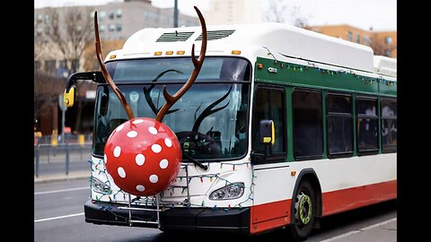A Newflyer Citybus decorated for the holidays with festive lights and a Red Noise ball, in an urban