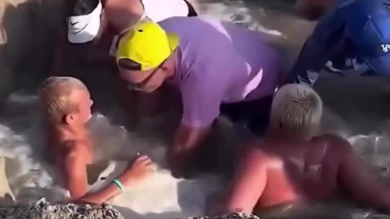 Two kids get trapped in the sand after water entered a hole they dug...