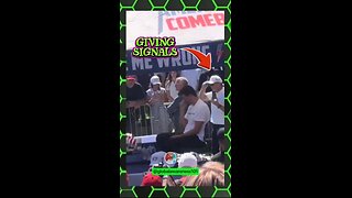 2 guys standing behind Charlie Kirk giving hand signals to shooter