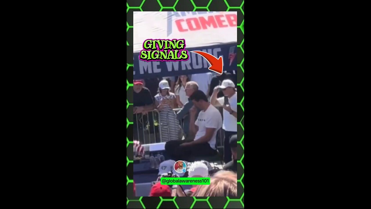 2 guys standing behind Charlie Kirk giving hand signals to shooter