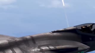 F-35C Lightning II flies over Florida coast while a SpaceX rocket is launched