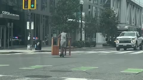 Woman Carries Bookshelf on a Scooter