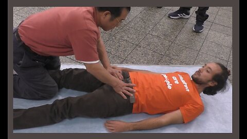 Luodong Massages White Man In Orange Shirt In The Subway Station