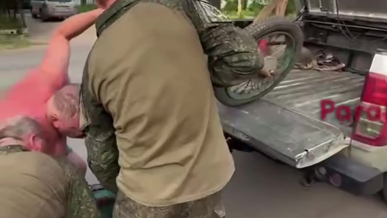 Woman Smiles and Waves While Being Looted by Russian Soldiers