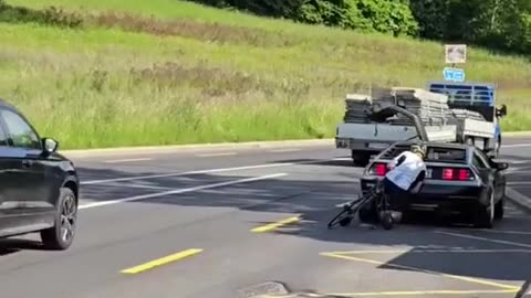 Delorean car gets rear ended by pushbike.
