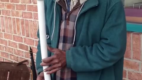 Musician playing a saxophone he made from PVC pipes