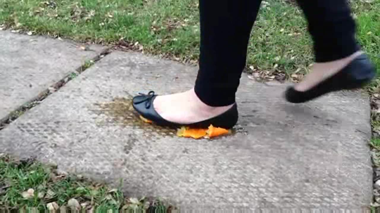 Black Flats Crush Orange on Sidewalk