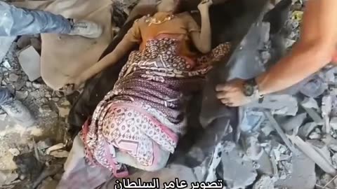A little girl lies martyred beneath the rubble of a residential building in Tel al-Hawa (Graphic)