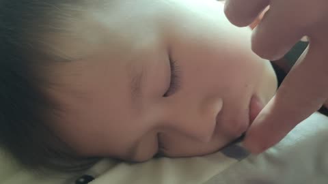 teasing the child while he is sleeping