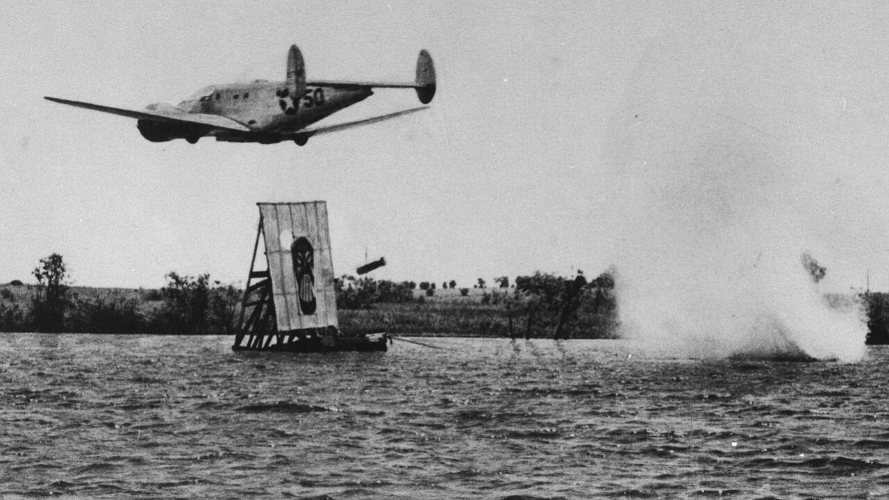 Beechcraft AT-11 Kansan trainers demonstrate skip bombing at Lake Childress in Texas