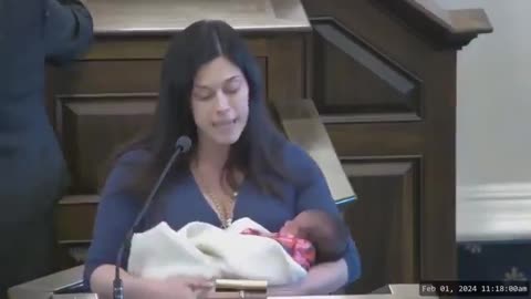 New Hampshire State Rep Amanda Toll (D) holds her newborn baby while speaking in support