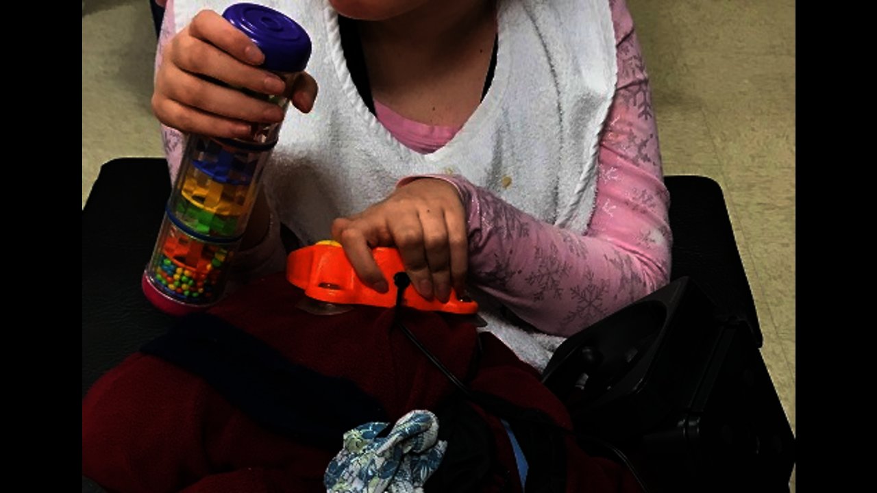 Girl with Developmental Disabilities Presses Switch Using Toy or Hand