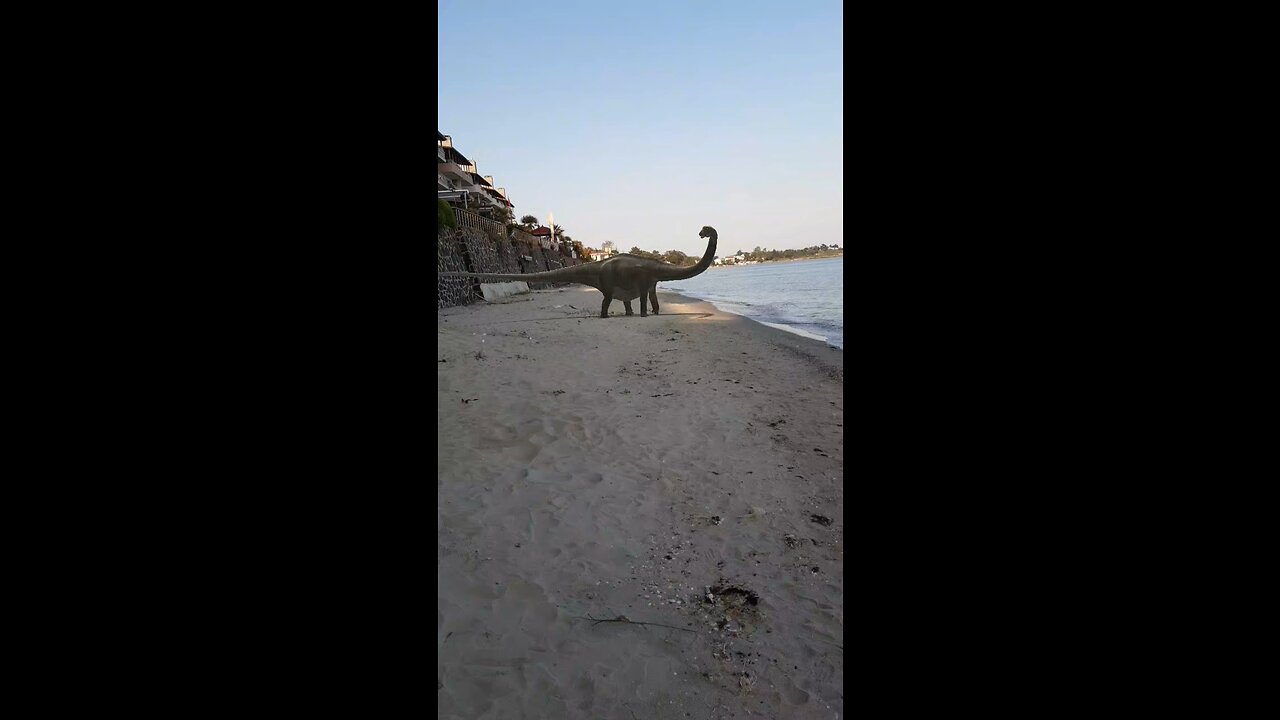 A dinosaur on the beach.