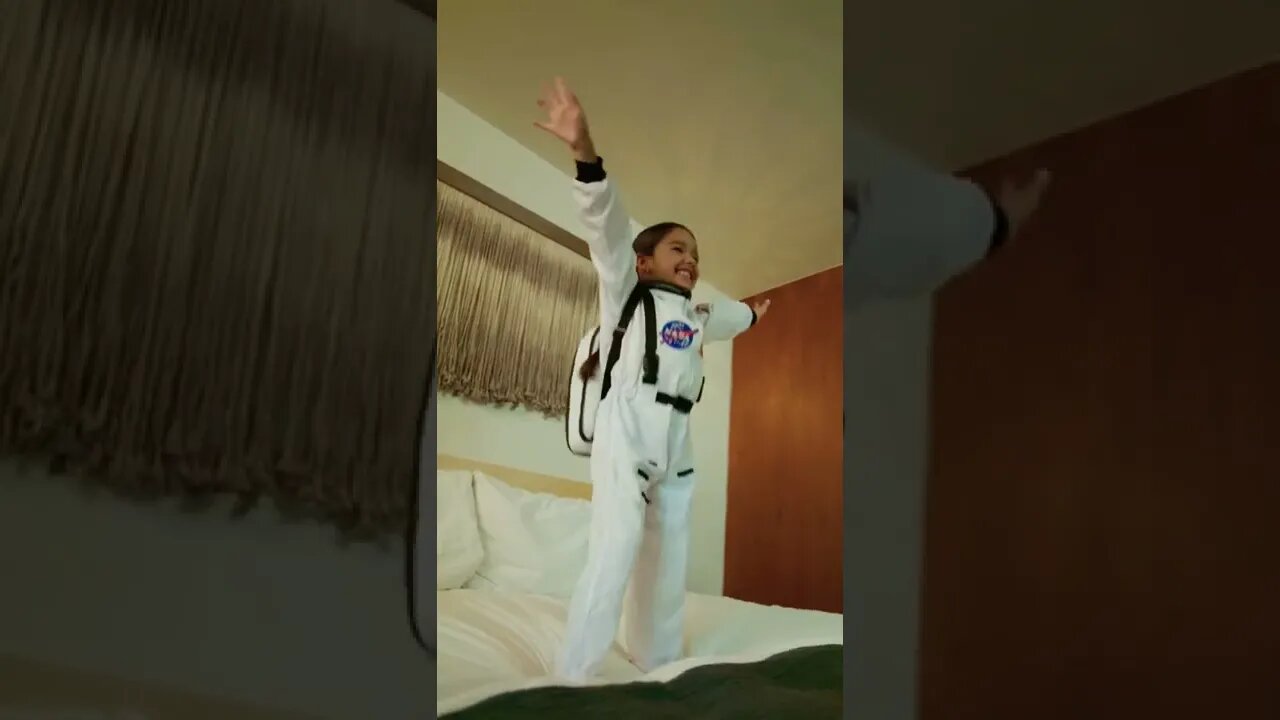 Cute Astronaut Girl Jumps On Bed