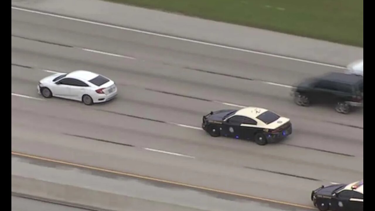 Watch How Suspect clings to moving car while fleeing police