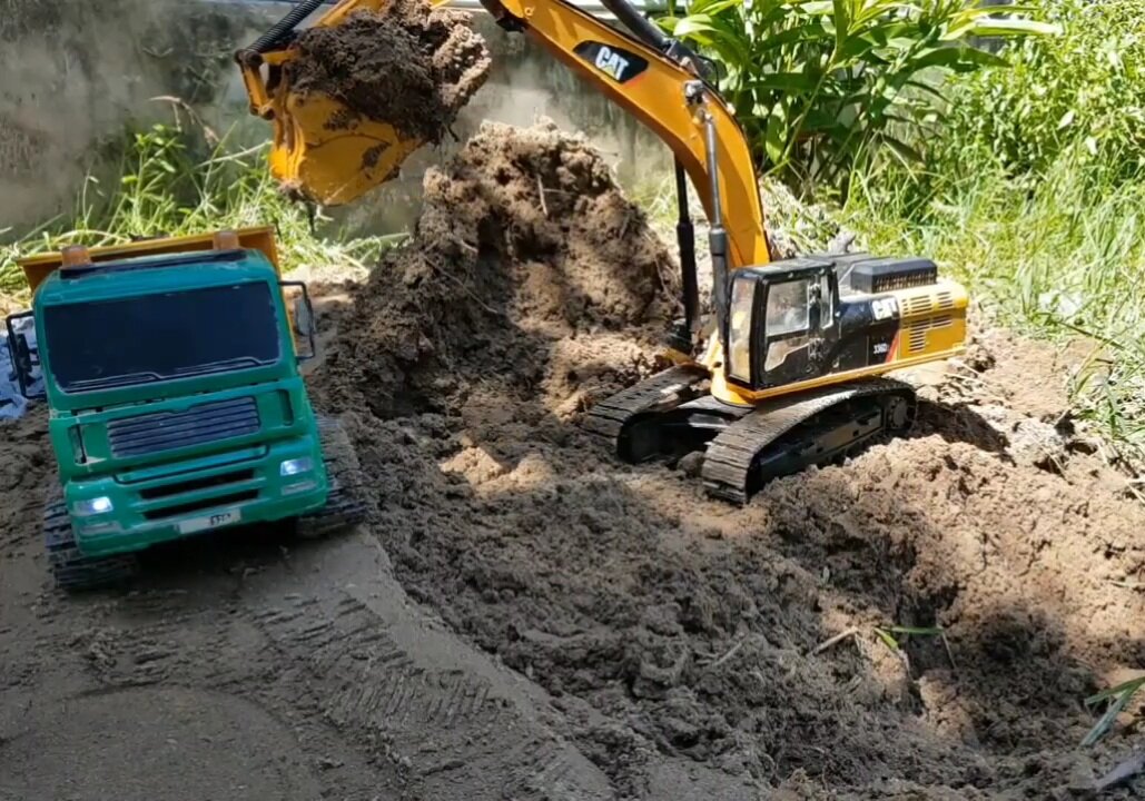 RC Excavator fills soil to green dump truck