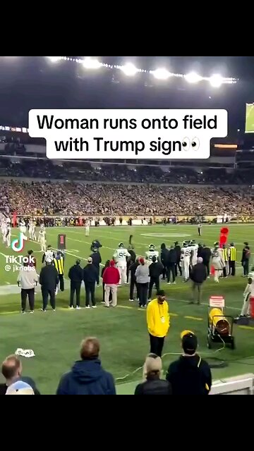 woman run onto football field with Trump sign