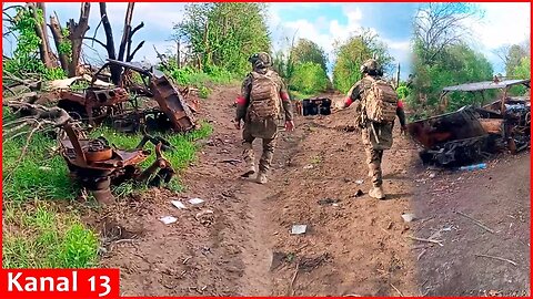 Russian soldiers show Russian military equipment destroyed on the "road of death" near Volchansk