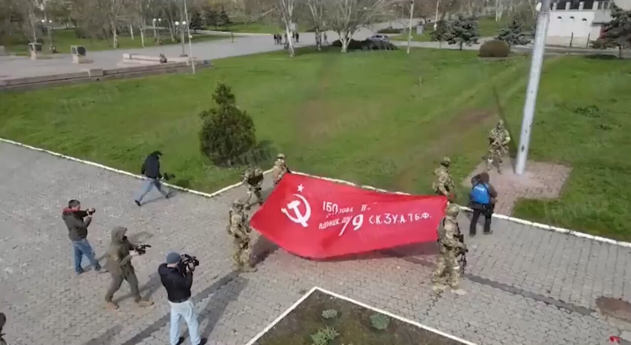 Russians raise Banner over the Alley of Glory in #Kherson. Zero towns people attended!
