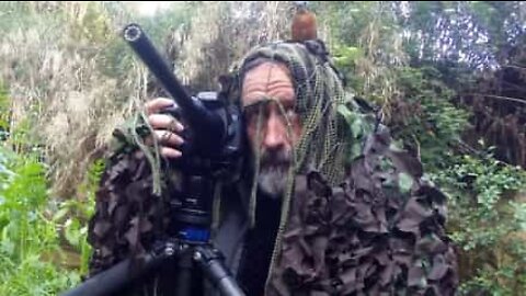Pássaro pousa na cabeça de fotógrafo camuflado!