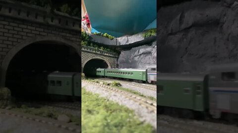 N scale passenger train leaving a tunnel