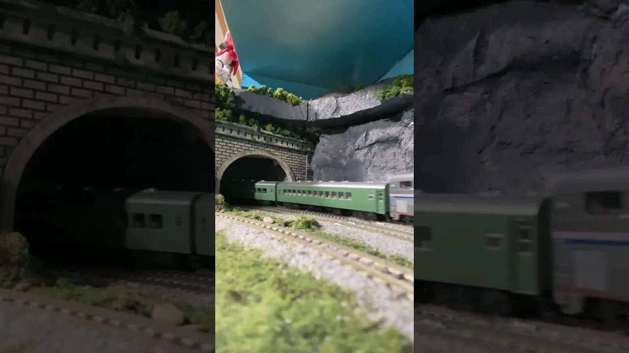 N scale passenger train leaving a tunnel