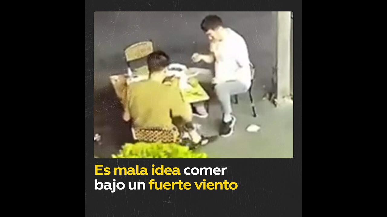 Fuerte viento sorprende a dos hombres durante una comida