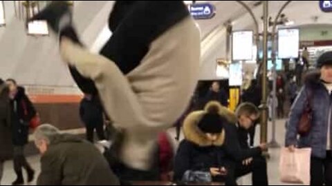 Guy in busy metro station does somersault out of nowhere