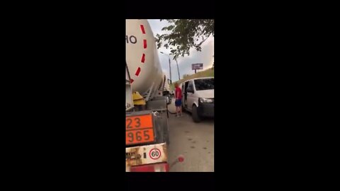 A Ukrainian citizen shames a compatriot who drains gasoline from a tanker while others stand in line