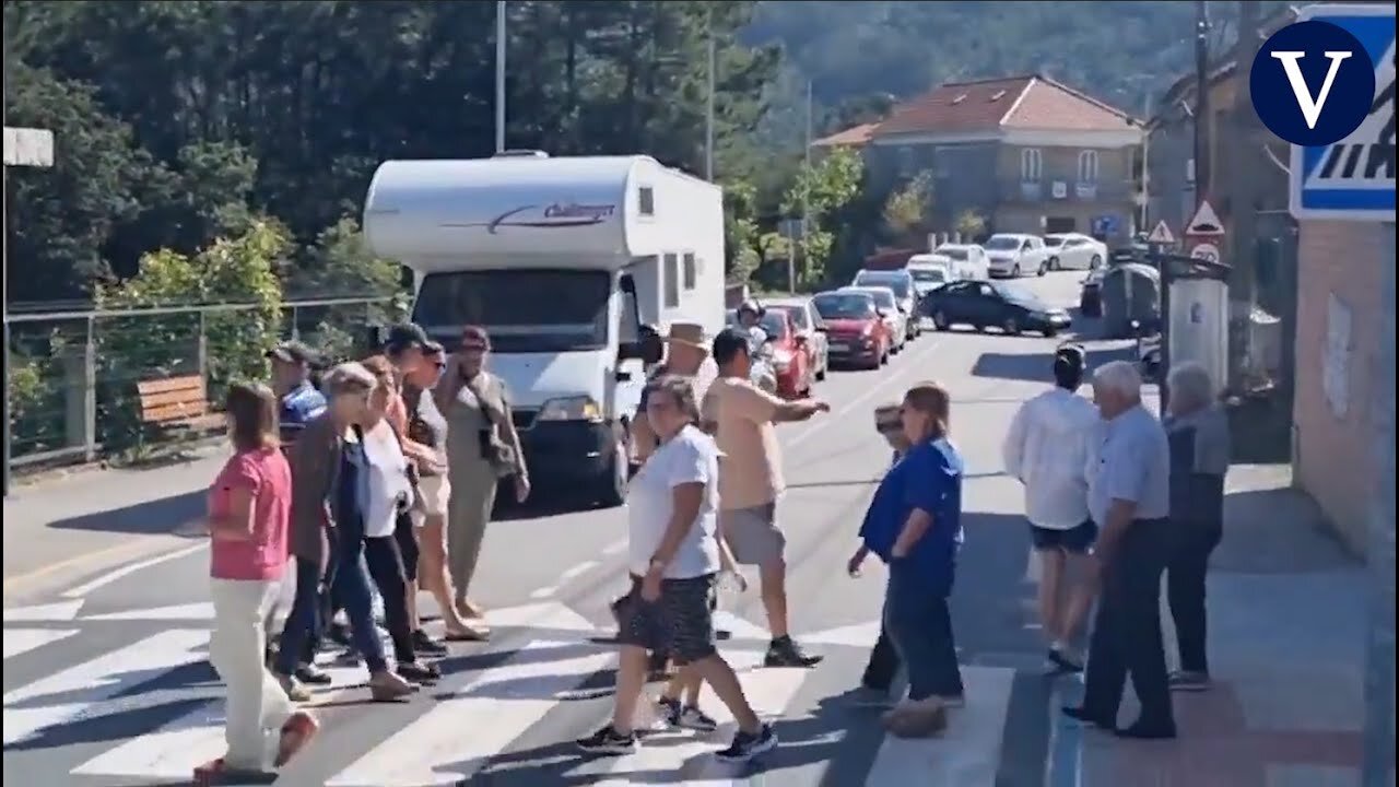 Un grupo de vecinos se manifiesta pasando continuamente por un paso de peatones