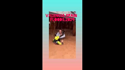 firefighters rescue a person and his puppy from drowning in the water of floods in Valencia, Spain.