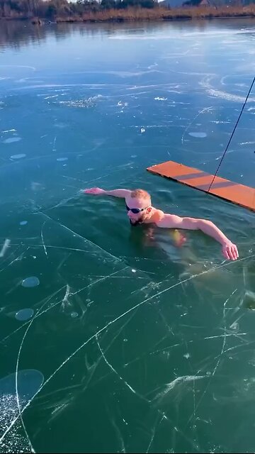 Ice swimmer panics under frozen lake in chilling video