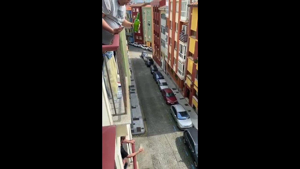 Man in Italy pours a drink for his neighbor two floors below