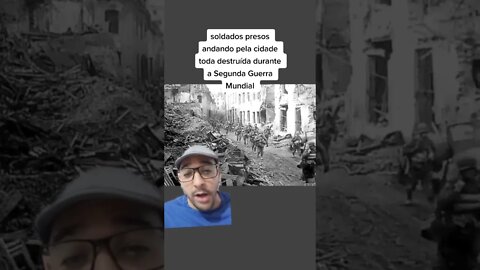 Soldados presos andando pela cidade toda destruída durante a Segunda Guerra Mundial.