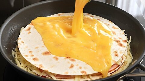 Flatbread with cheese, sausage, tomatoes and eggs, fried in a pan until golden brown