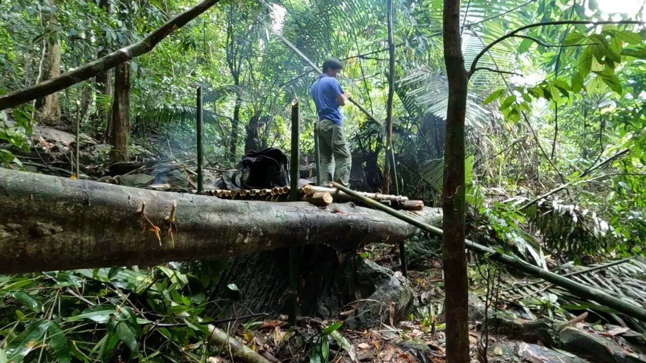 Building a bamboo shelter on a rock face:14