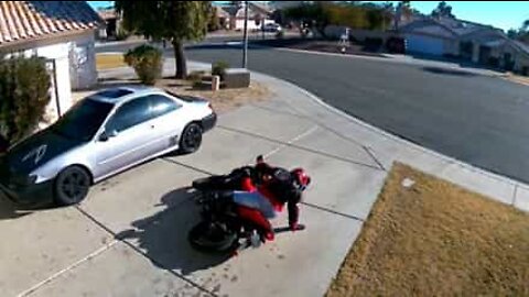 Biker struggles to lift up her motorcycle
