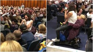 Comedian Russel Brand catches a ride on fan's mobility scooter