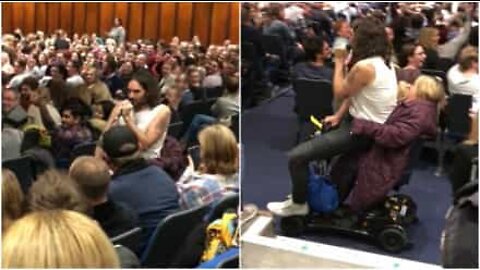 Comedian Russel Brand catches a ride on fan's mobility scooter