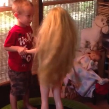 A Little Boy Dances and Kisses A Life Size Doll On A Trampoline