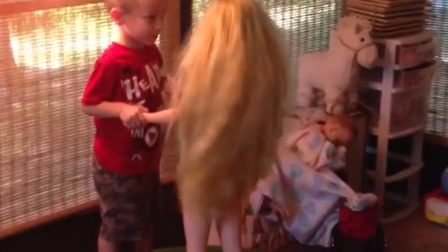 A Little Boy Dances and Kisses A Life Size Doll On A Trampoline