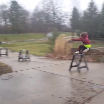 Young Boy Runs And Jumps Over A Sawhorse Like It's A Hurdle