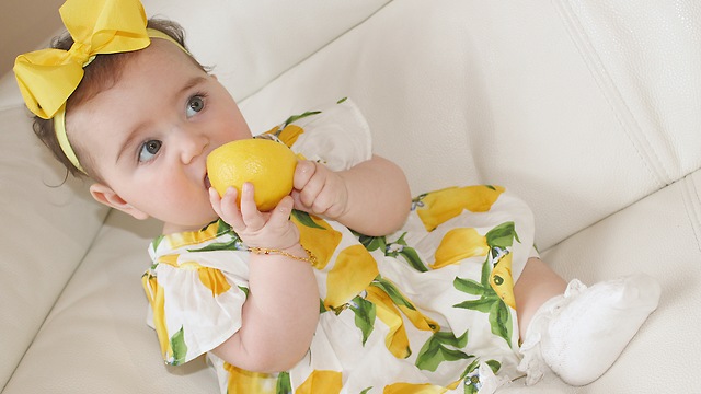 Baby tasting lemon for the first time