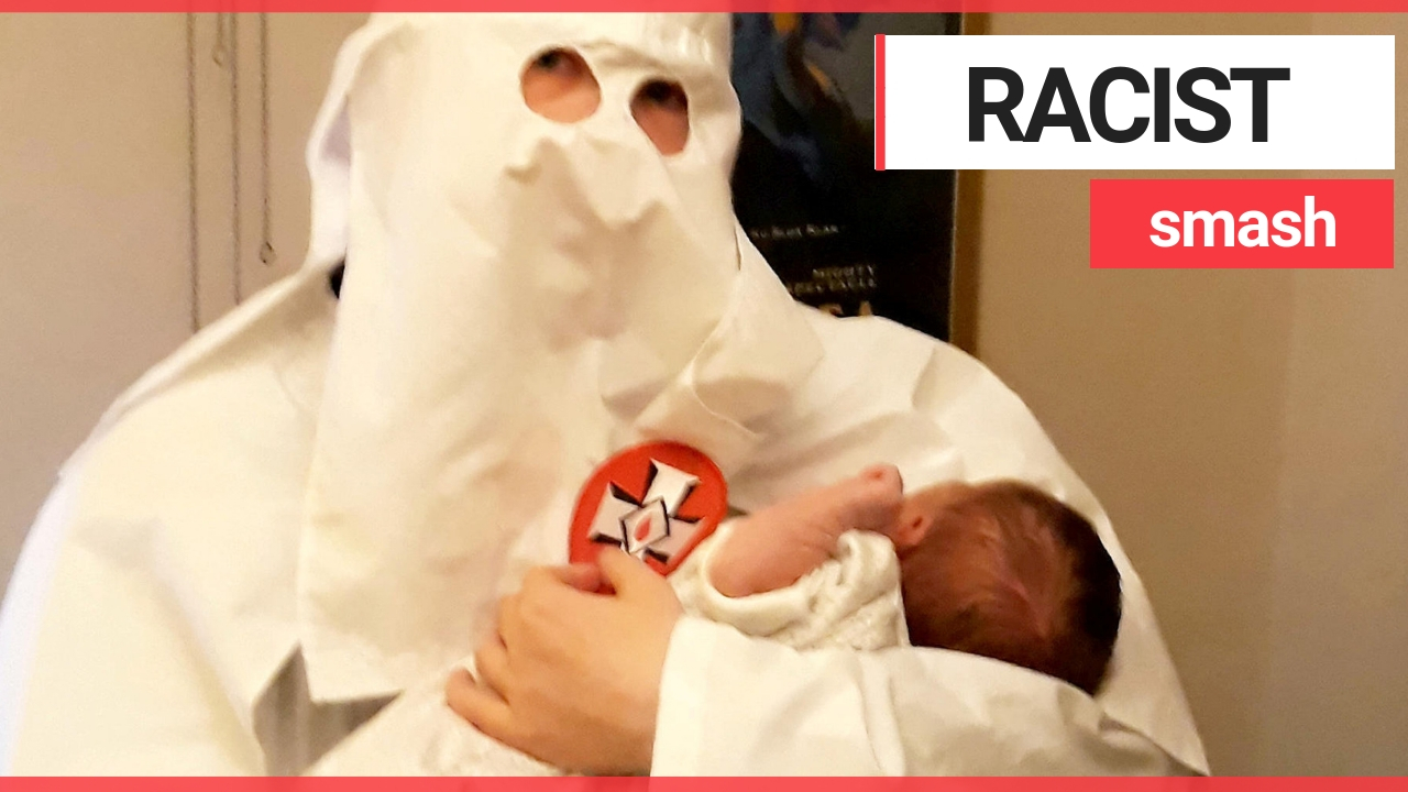 Dad pictured holding his baby dressed in Ku Klux Klan robes