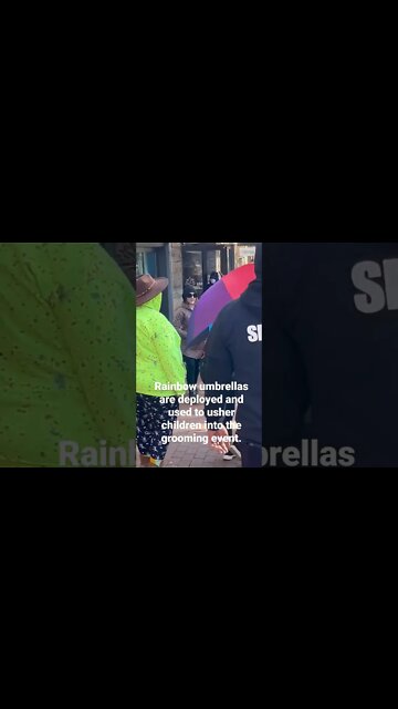 Rainbow umbrellas are deployed and used to usher children into the grooming event.