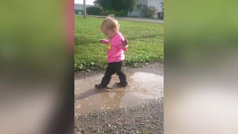 A Tot Girl Runs Into The Bumper Of A Car While She Walks In Puddles