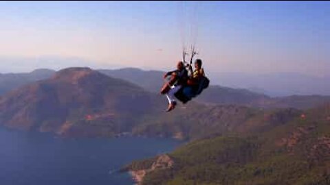 Senhor toca violoncelo enquanto faz paragliding!