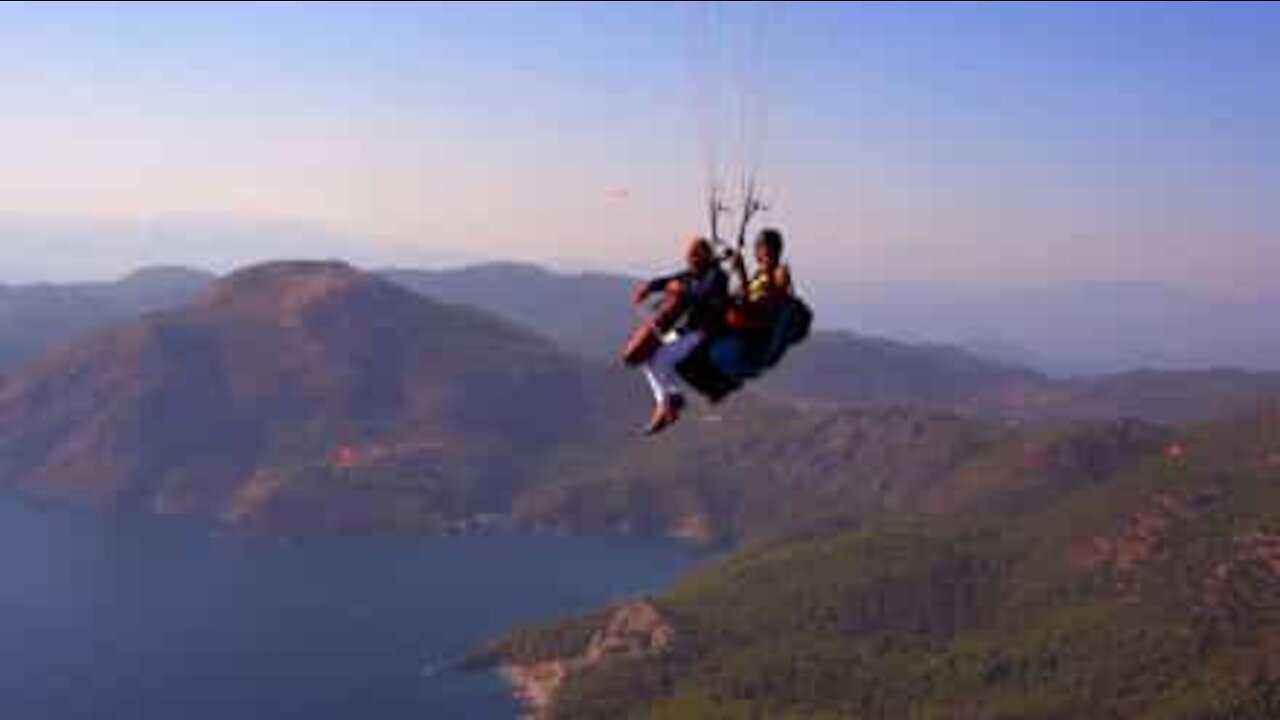 Senhor toca violoncelo enquanto faz paragliding!