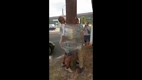 Two people are bound to a pole for public humiliation in Dnipro, Ukraine